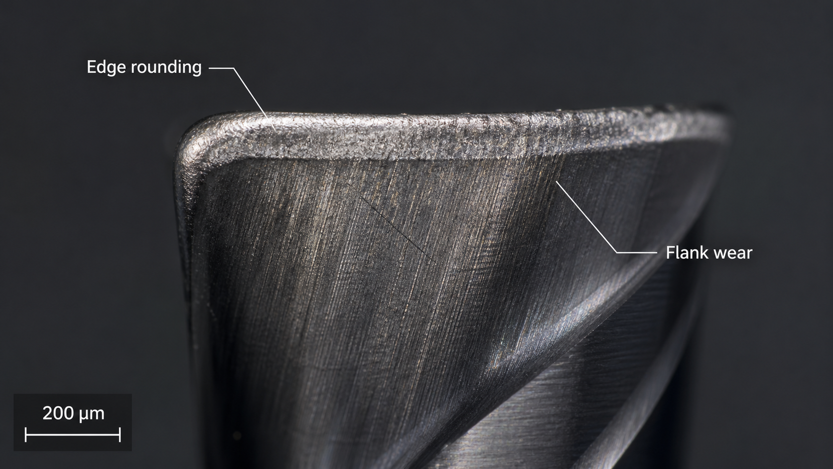 Microscopic Inspection of Cutting Edge Wear A microscopic image showing the worn, rounded cutting edge of a carbide end mill after machining abrasive material